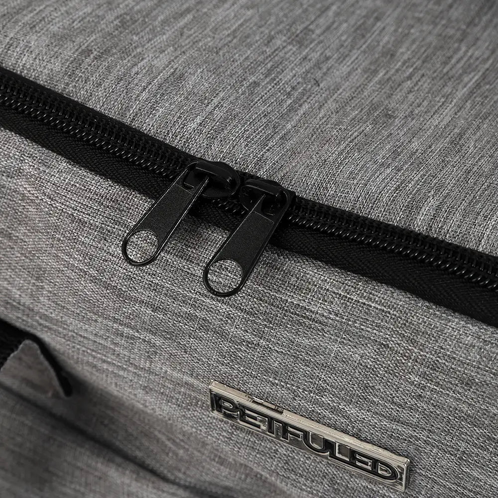 Sac de voyage pour chien en tissu gris chiné, avec fermeture éclair, comprenant des tirettes de fermeture éclair noires et une étiquette de marque métallique reifuled.
