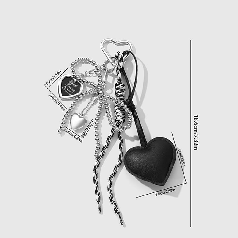 Black heart-shaped leather keychain with silver-toned metal bowknot charms and chains for bags.