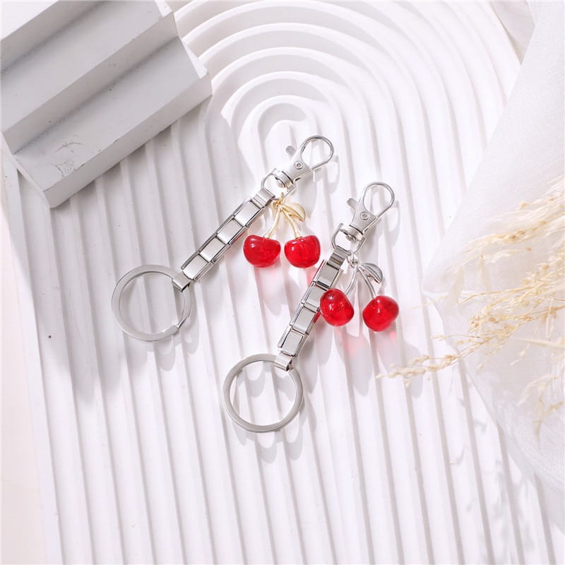 Llavero con dije de eslabones italianos con acabado plateado, con dijes de cereza roja y un diseño de cadena modular para uso personalizado en bricolaje.