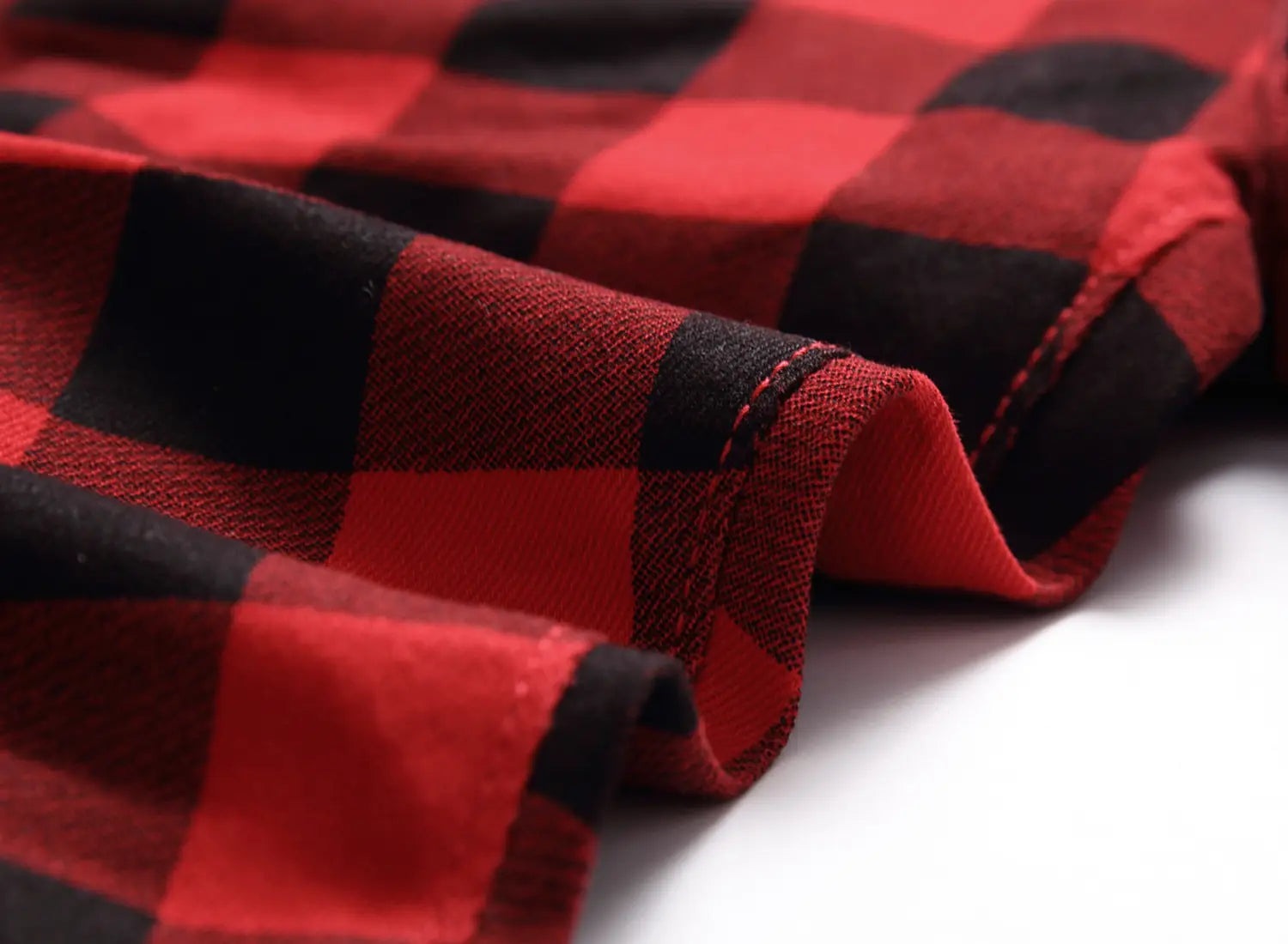 Jeans en denim rouges à carreaux, coupe slim ajustée, fabriqués dans un tissu à carreaux rouge et noir, avec une couture visible le long du pli