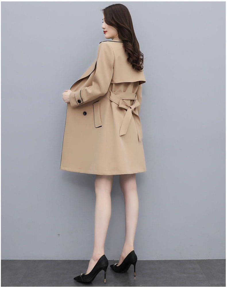 Beige women double breasted trench coat with black trim and matching belt designed for stylish outerwear.