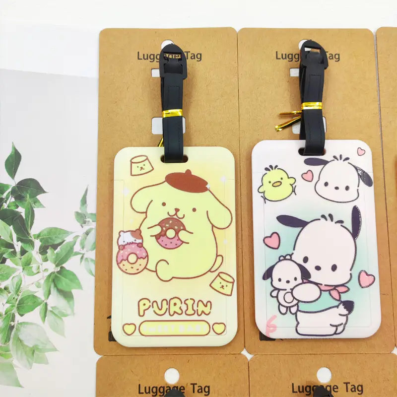 Ensemble d’étiquettes de bagage Hello Kitty comportant des adorables étiquettes de personnages de dessin animé jaune et blanc, avec des sangles noires pour l’identification de la valise.