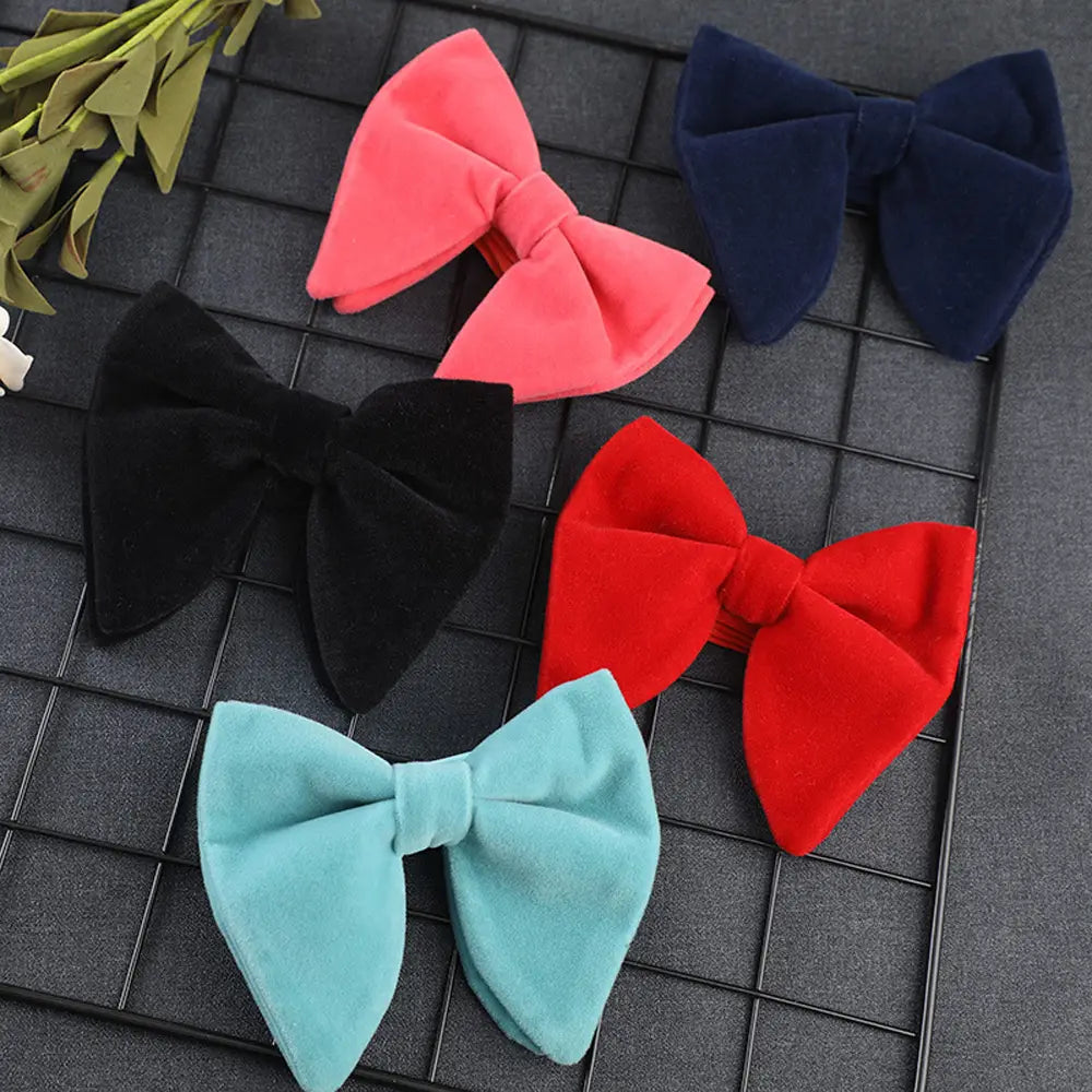 A collection of five velvet bow hair clips in vibrant pink navy blue black red and light teal suitable as formal neckwear gifts.