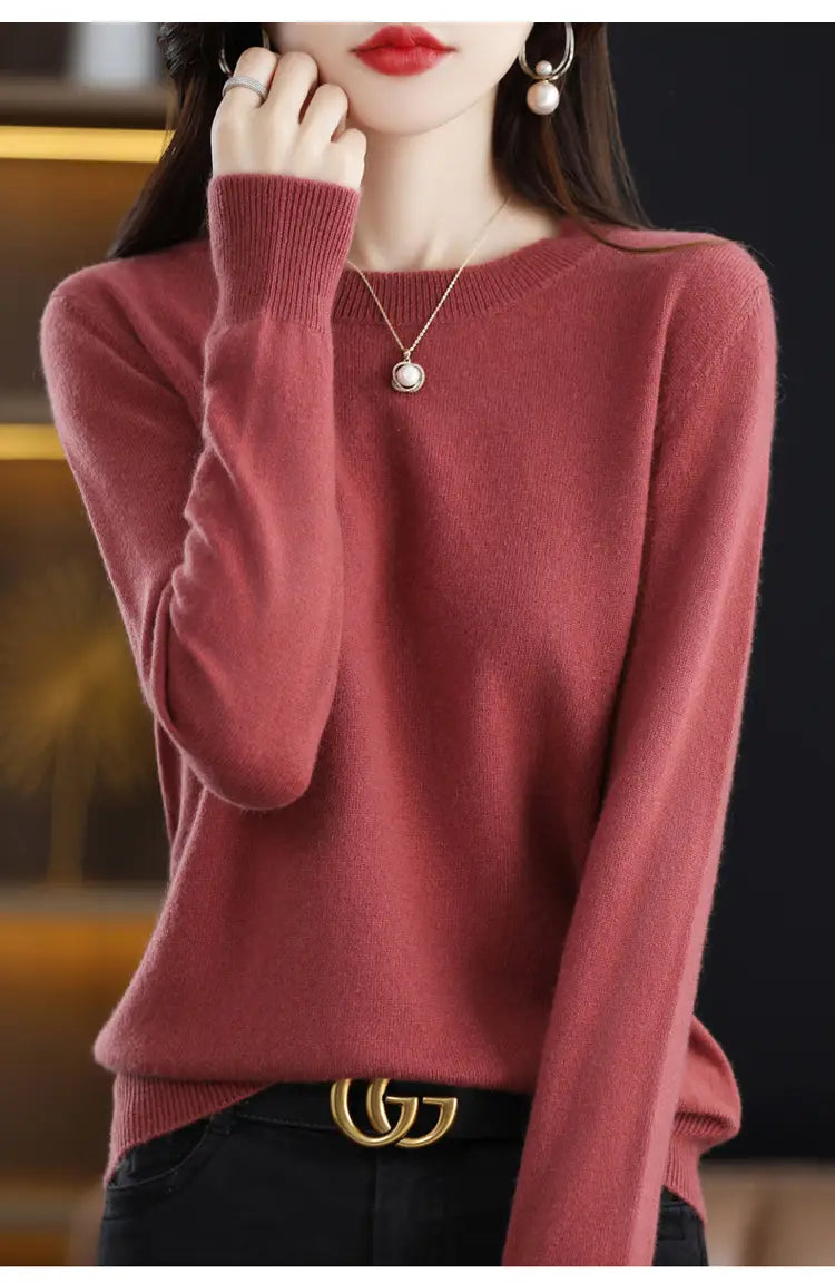 A soft dusty rose-colored pure wool cashmere o-neck pullover sweater with long sleeves and ribbed cuffs.