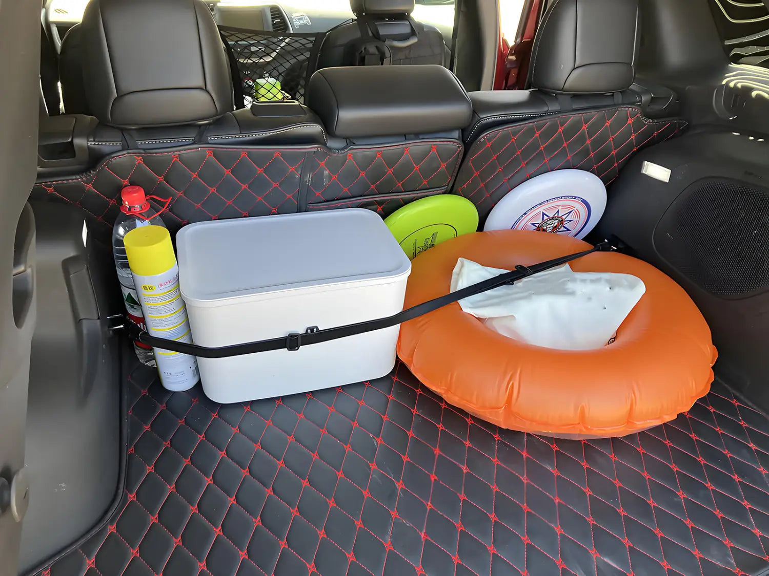 white rectangular cooler with black elastic cargo strap displayed as part of a car trunk organizer setup viewed from above