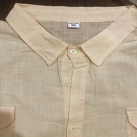 Beige linen short sleeve button-up shirt with a subtle woven texture and two chest pockets for casual summer wear.