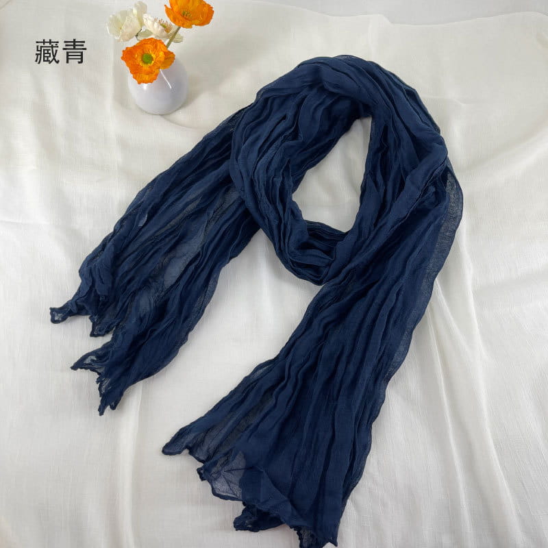 Écharpe en coton et lin plissé bleu marine en mousseline de chiffon, à la texture froissée légère et aux bords légèrement effilochés.