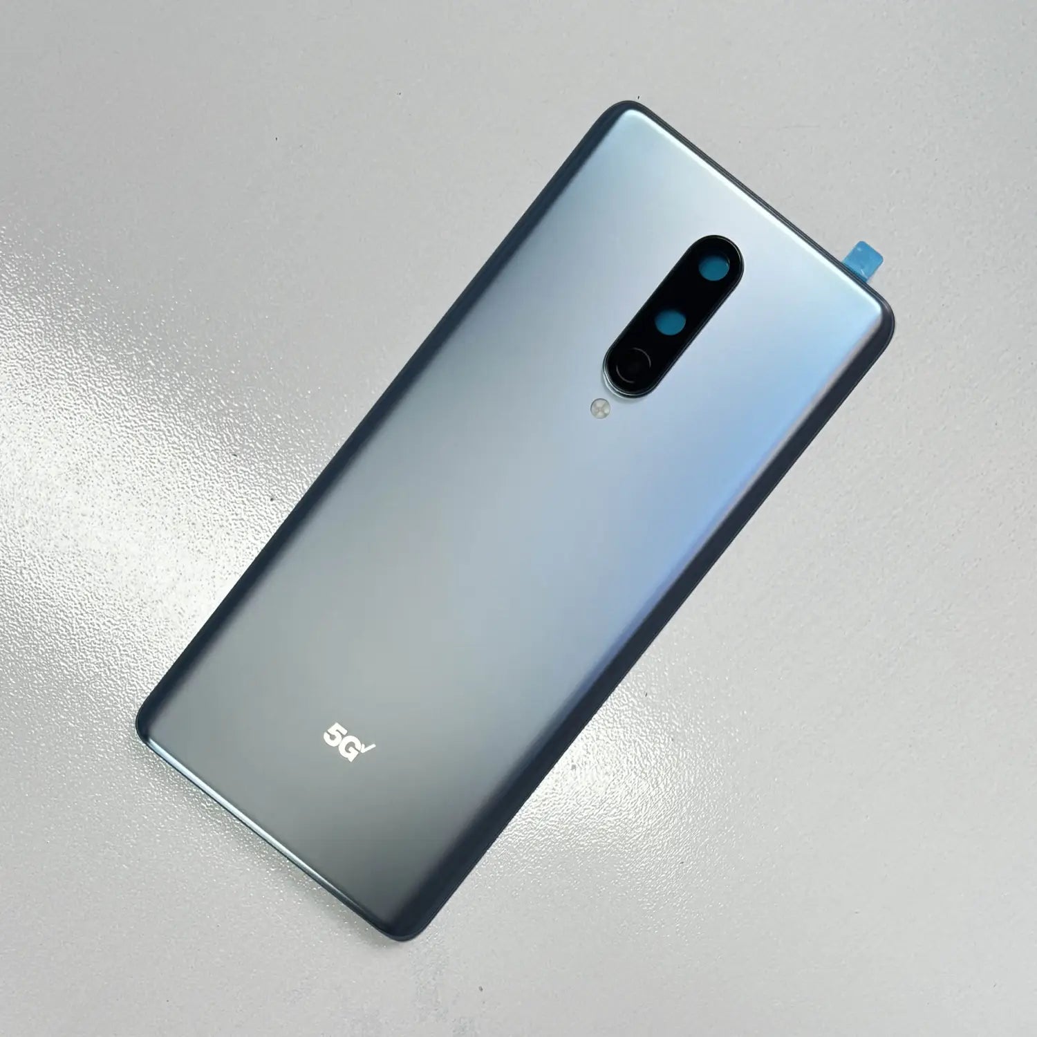 Rückseite der silberfarbenen Farbverlauf-Akkufachabdeckung aus hochwertigem Gorilla-Glas für Oneplus 8 Pro mit vertikalem Triple-Kameramodul und 5G-Logo