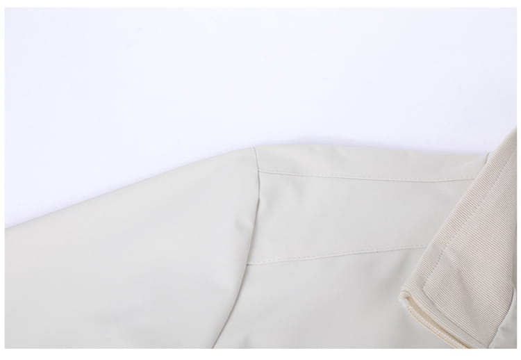 Chaqueta cortavientos ligera para hombre en color beige con cuello vuelto, que presenta un estilo de cuello tipo gabardina con costuras sutiles y tejido texturizado.