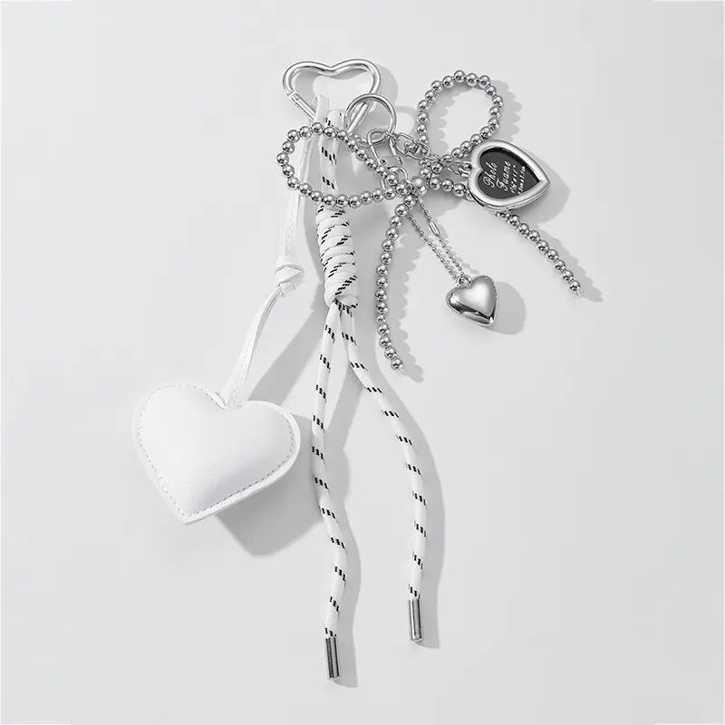 White heart-shaped leather charm with black stitching and silver-toned metal hardware for heart pendant bowknot bag keychain.