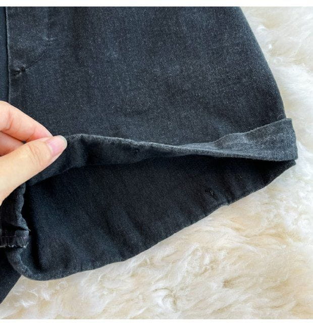 black denim shorts with a slightly faded worn-in look and rolled cuffs as part of a denim jumpsuit off shoulder summer romper