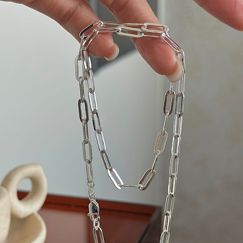 Collar minimalista de cadena tipo eslabones de papel en plata de ley, con un acabado metálico pulido y tono plateado, de aspecto sofisticado, y un cierre seguro.