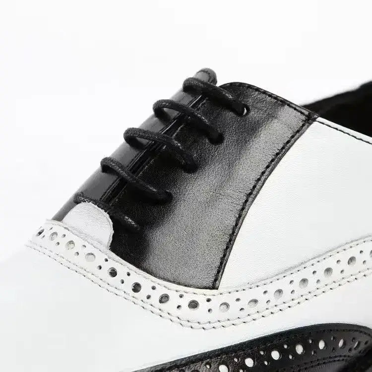 Zapato de vestir Oxford tipo brogue bicolor para hombre en cuero negro y blanco con detalles perforados.