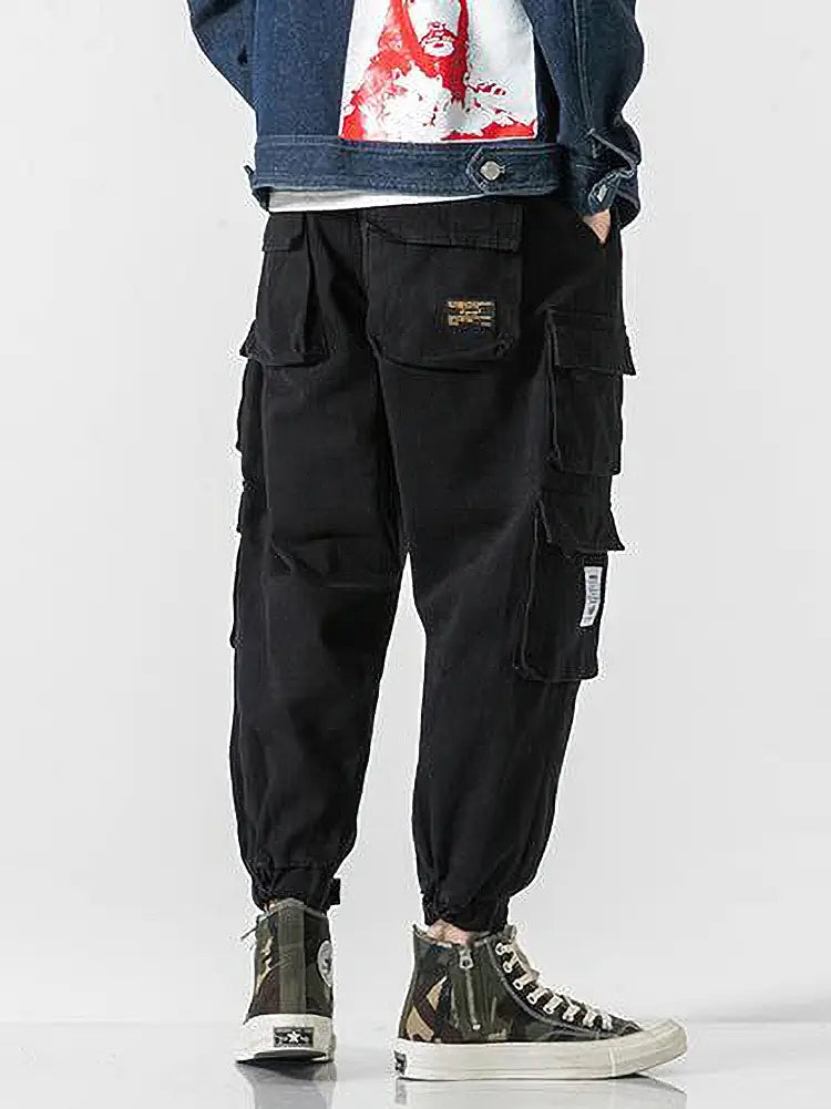 Pantalon jogger cargo coréen noir pour hommes, doté de plusieurs poches et d’une ceinture à cordon de serrage, conçu pour une tenue décontractée ample.