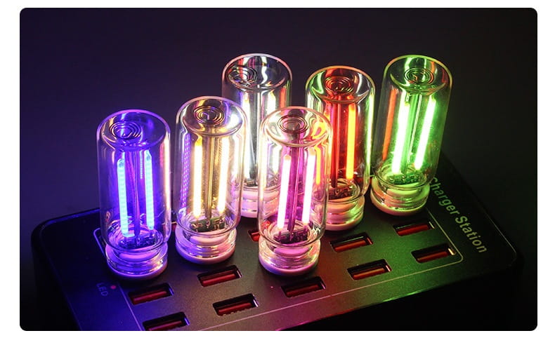 Seven cylindrical usb night light glass tubes with clear glass casing and glowing filaments emitting vibrant purple, orange, pink, red, and green colors for a touch color changing atmosphere light.