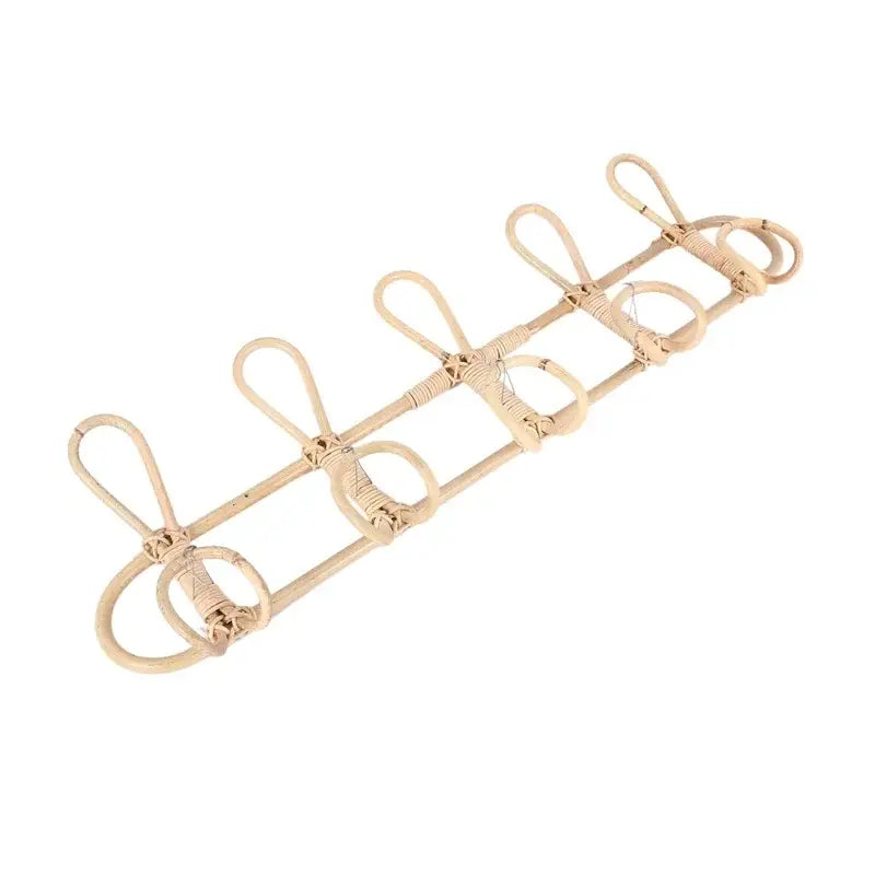 Natural beige rattan wall-mounted coat rack with five curved hooks designed as a kids wall hanger organizer.