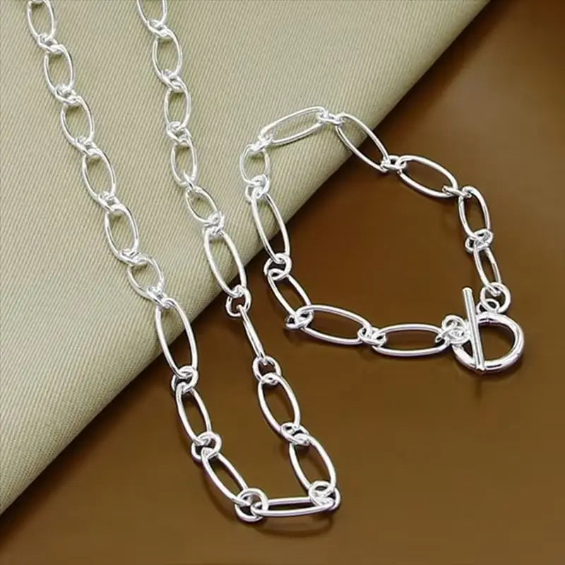 Schmuckset aus 925er Silber mit ovaler Gliederkette, bestehend aus Halskette und Armband mit Karabinerverschluss in Silber.