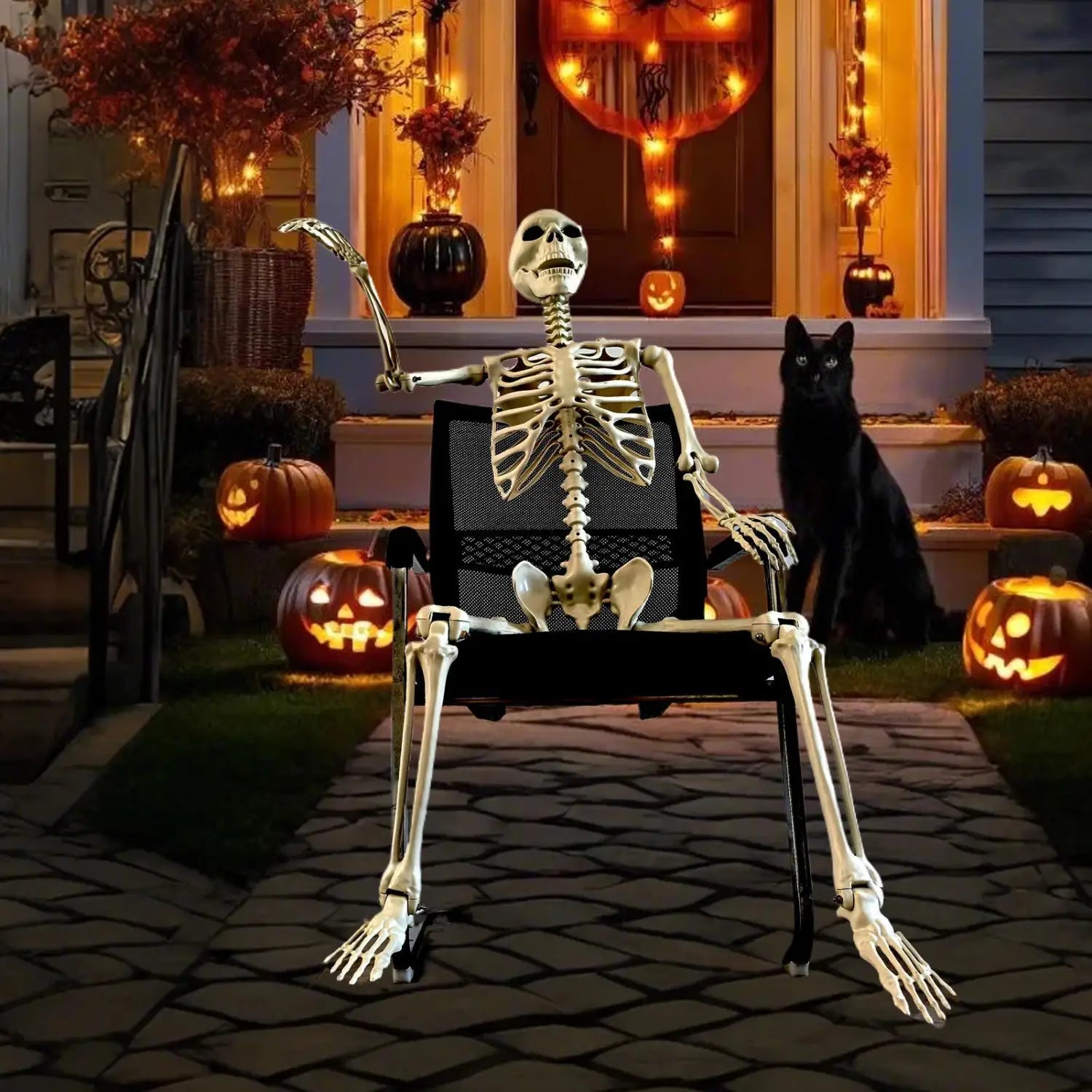 una decoración posable de esqueleto de Halloween de plástico color beige, sentada en una silla de oficina de malla negra, con un brazo levantado y el otro apoyado sobre su regazo, para exhibición de casa encantada