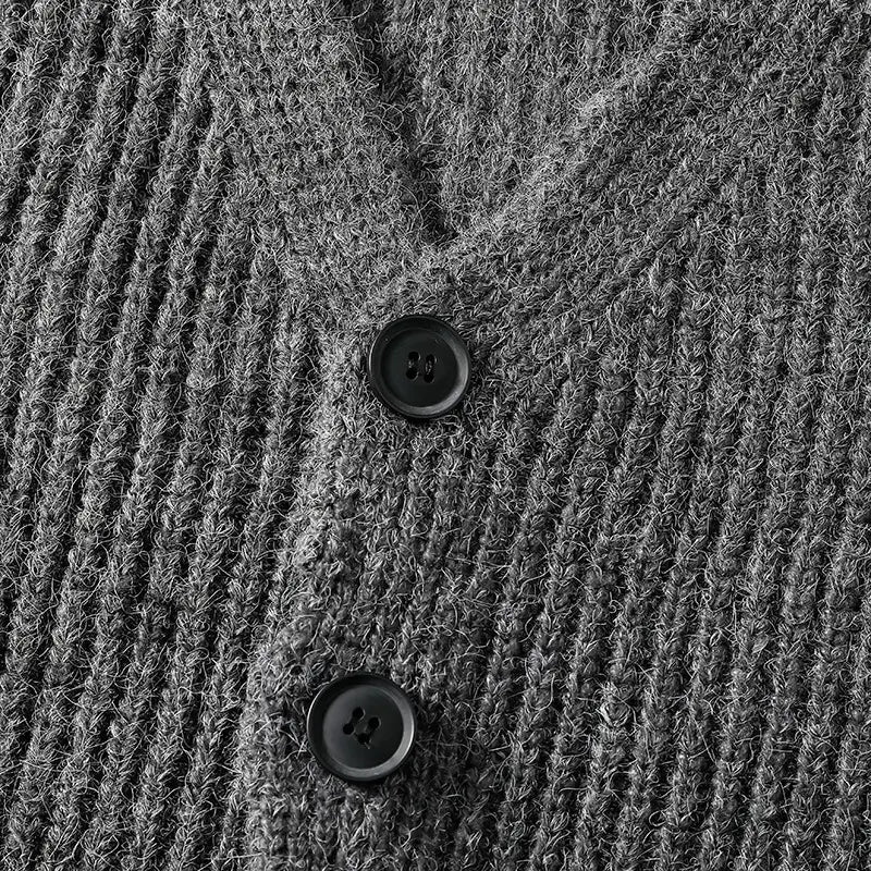 Ein Herren-V-Ausschnitt-Strickcardigan in dunkelgrauem, geripptem Strick mit zwei schwarzen Knöpfen.