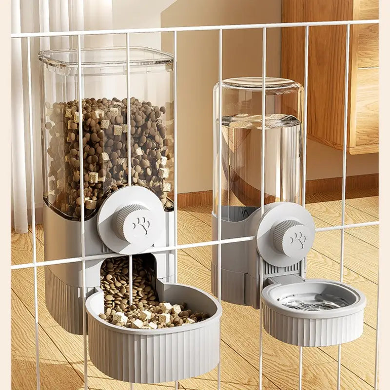 Gray pet feeder with transparent cylindrical water dispenser feeder mounted on a white wire rack designed for cage use.