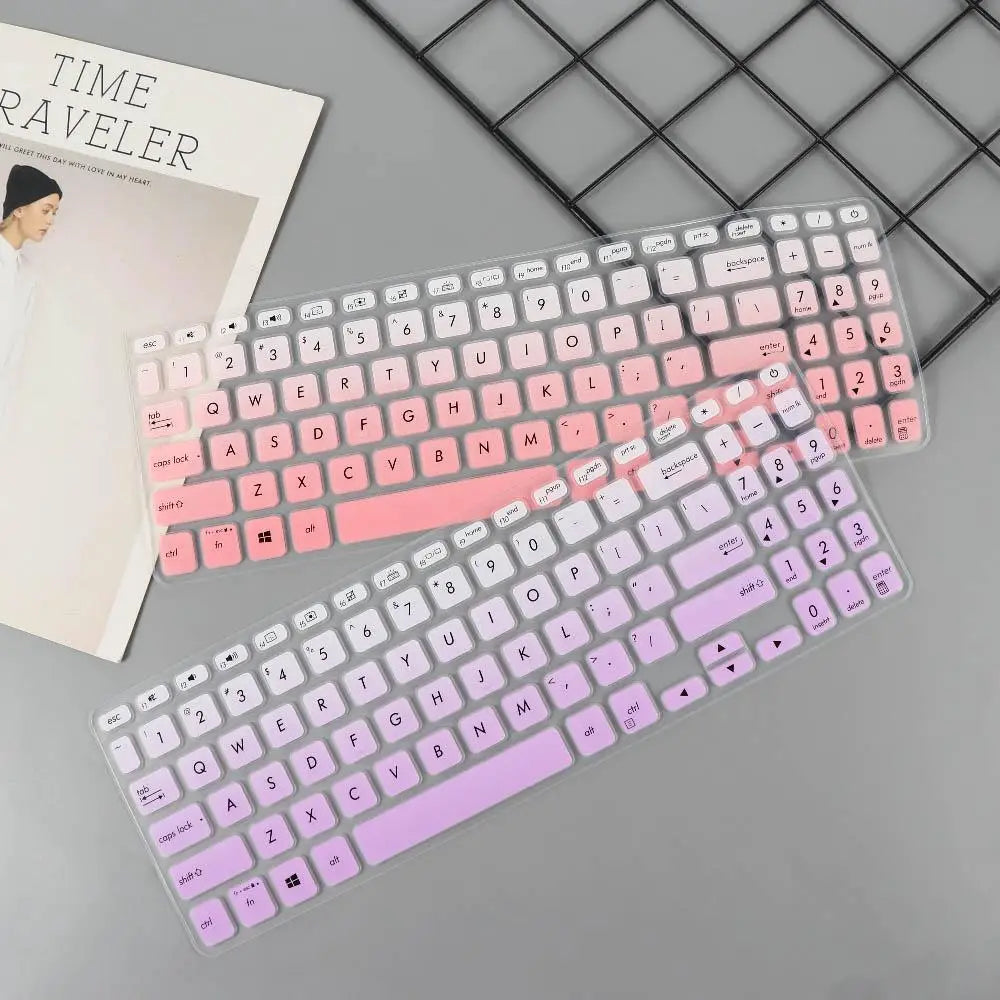 Two translucent silicone laptop keyboard covers in soft pink gradient and lavender designed to fit standard 15.6 inch laptops.