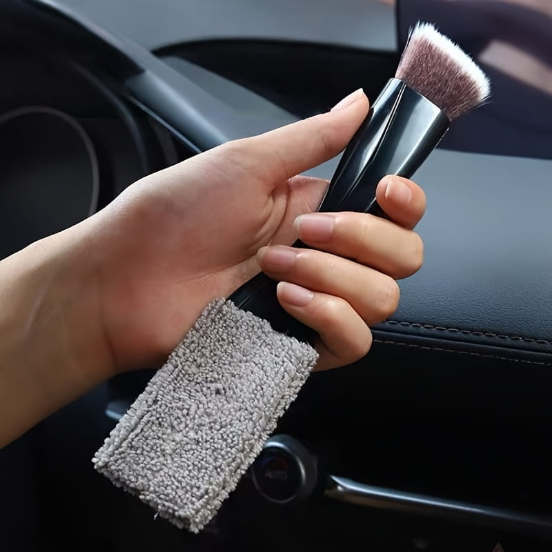 Brosse de nettoyage pour intérieur de voiture à poignée noire, avec sangle de préhension en microfibre grise, conçue pour un nettoyage et un dépoussiérage efficaces.