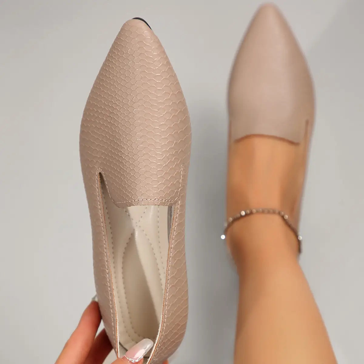 Mocasines planos de cuero color beige con estampado de piel de serpiente, punta afilada y diseño minimalista y elegante.