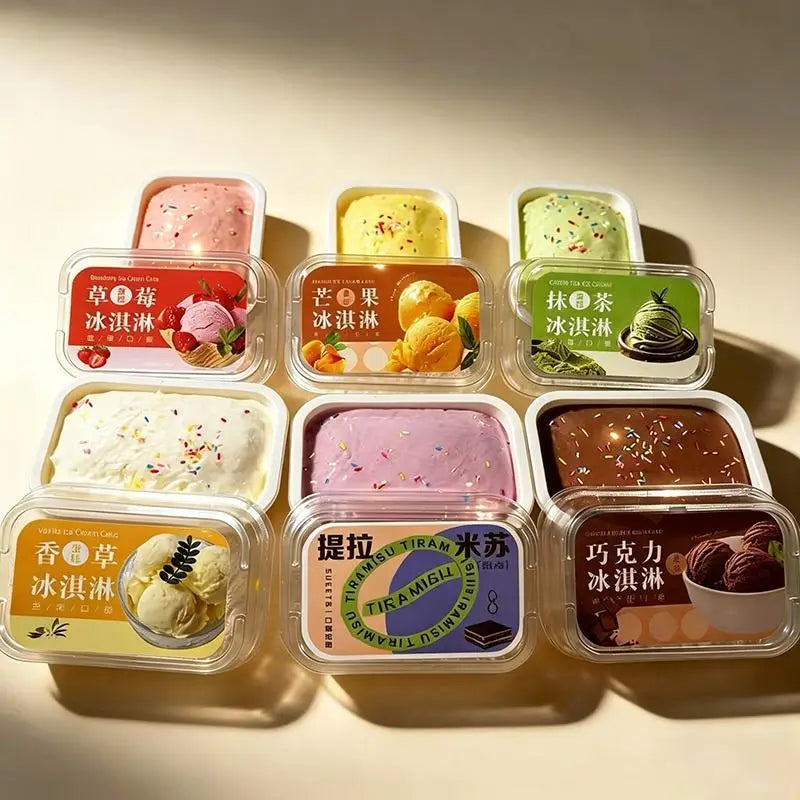 seis recipientes de plástico rectangular con juguetes sensoriales tipo fidget de pastel simulado de helado de crecimiento lento, con tapas transparentes y etiquetas coloridas con caracteres chinos para los sabores fresa, mango, matcha, vainilla, tiramisú y chocolate