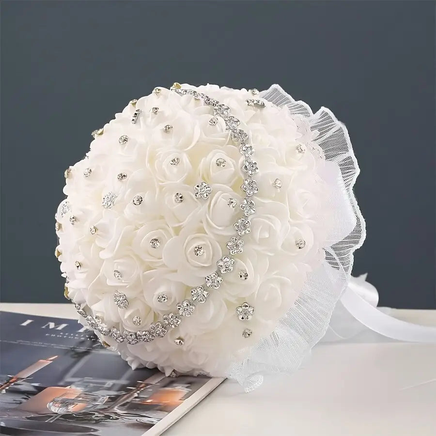 A delicate white bridal bouquet featuring soft fabric roses adorned with sparkling rhinestones and sheer lace trim.
