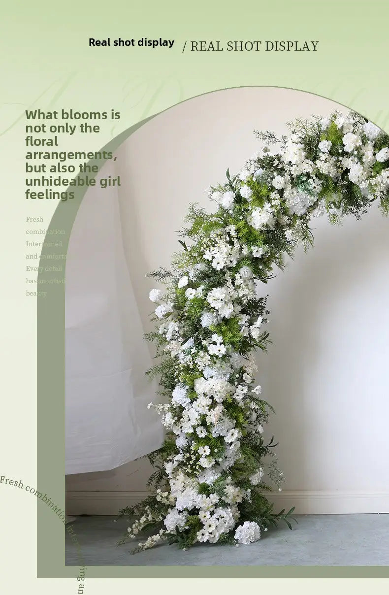 Arco floral para boda con soporte que presenta un arreglo arqueado y exuberante de rosas blancas artificiales y follaje verde.