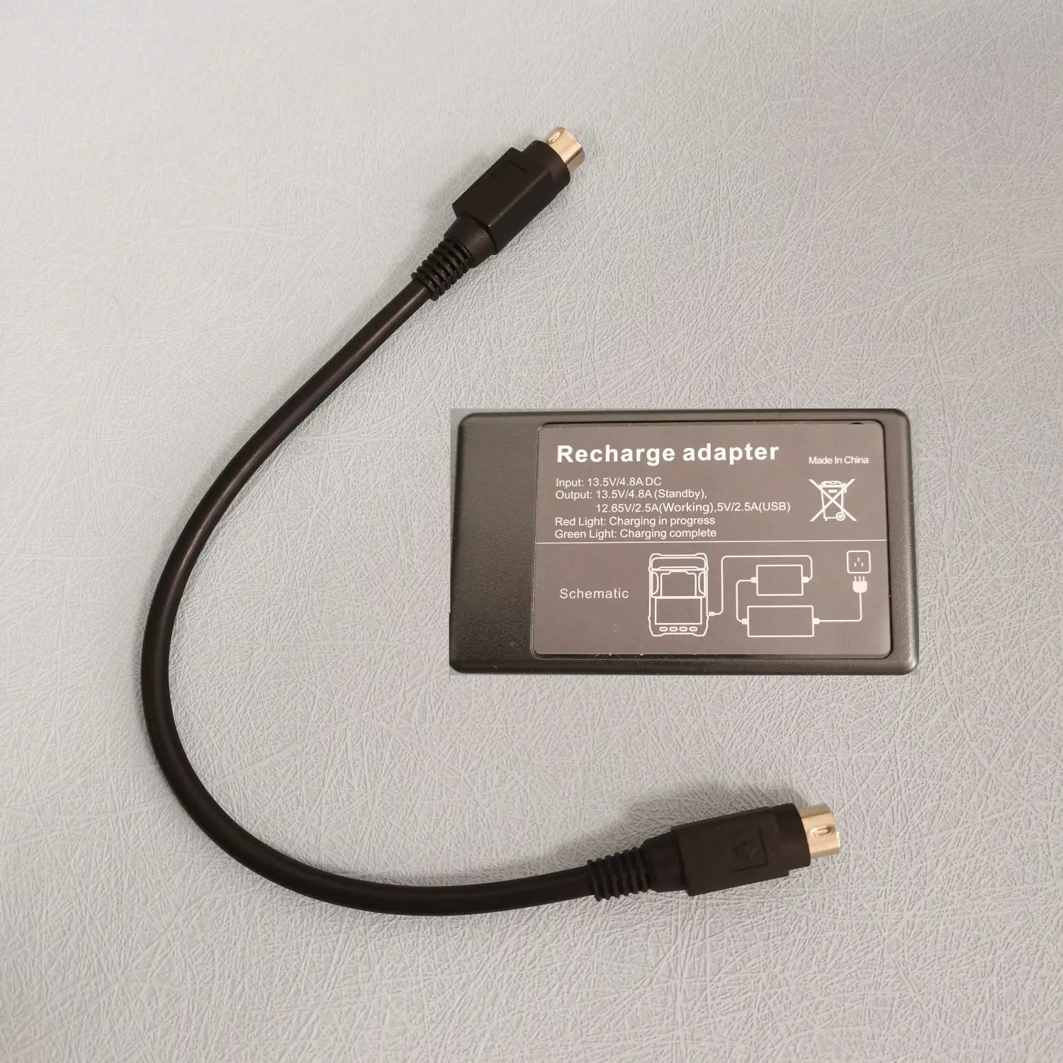 Schwarzer USB-zu-USB-Ladeadapter für das Netzteil des Signal Fire Fusion Splicer 12 V 8 A, Rückseite dargestellt, mit rechteckigem Aufkleber, der technische Spezifikationen und ein Schaltbild zeigt.