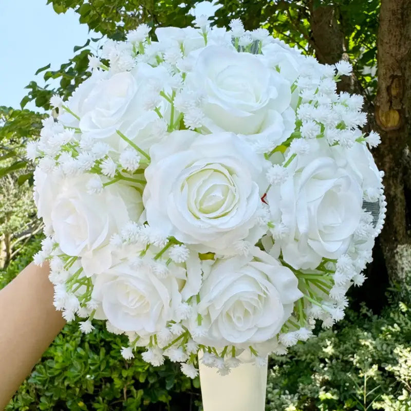 White silk rose wedding bouquet featuring lush white artificial roses with delicate baby’s breath accented by lace and pearls.