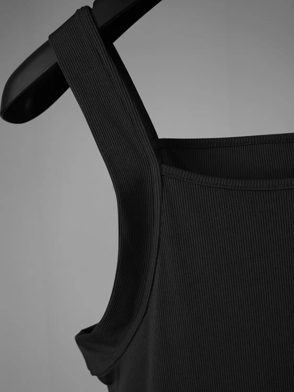 Black ribbed fabric men’s tank top with square neckline and wide shoulder straps.