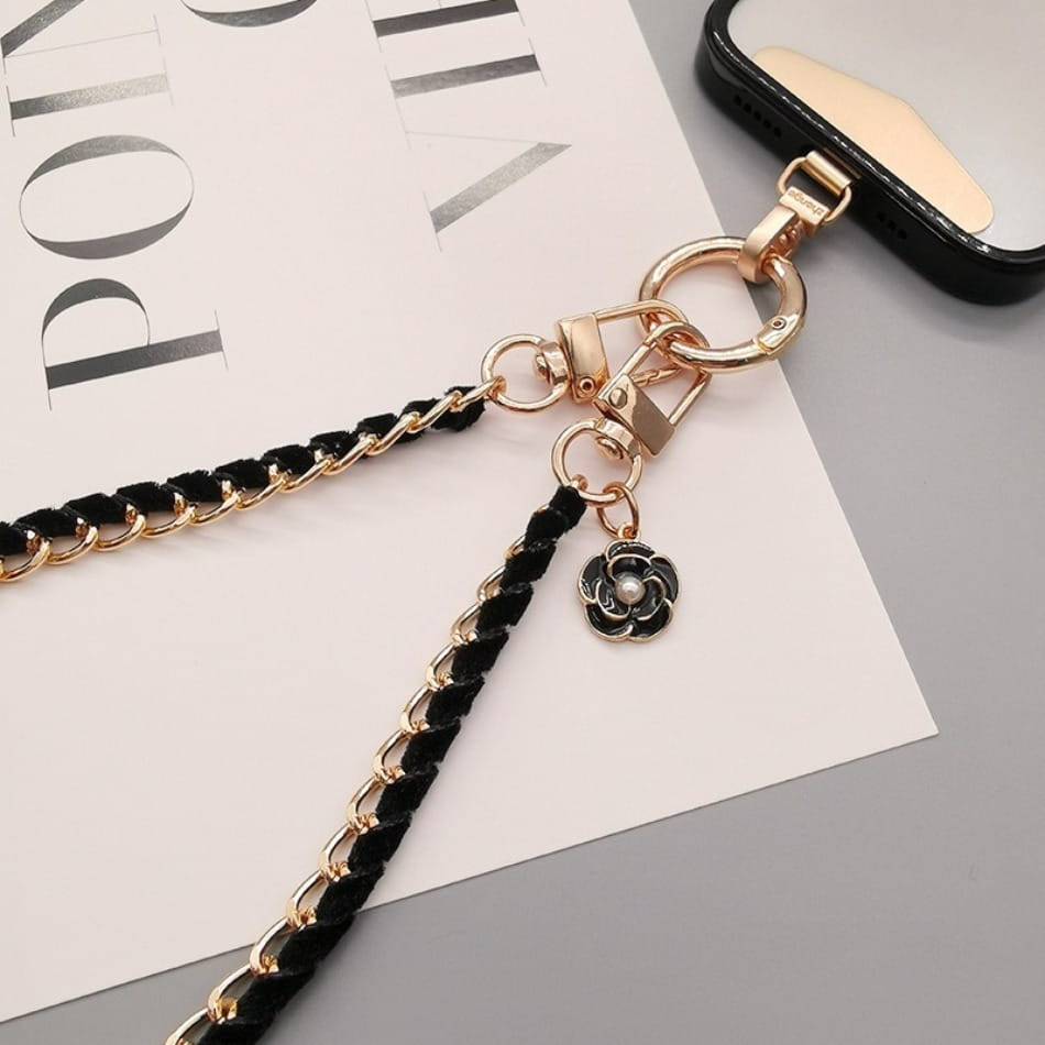 Schwarzer geflochtener Kord-Handy-Handgelenkriemen mit goldfarbenem Metall-Kettenverschluss und schwarzem Blumenanhänger mit Perlenmittelteil zur Verwendung als Anti-Lost-Handylanyard.