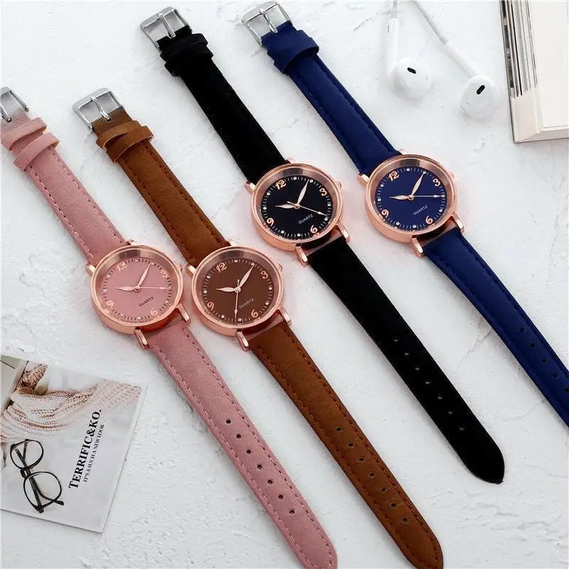 Four rose gold-tone women quartz watches with pink brown black and navy blue suede leather bands and rose gold dials.