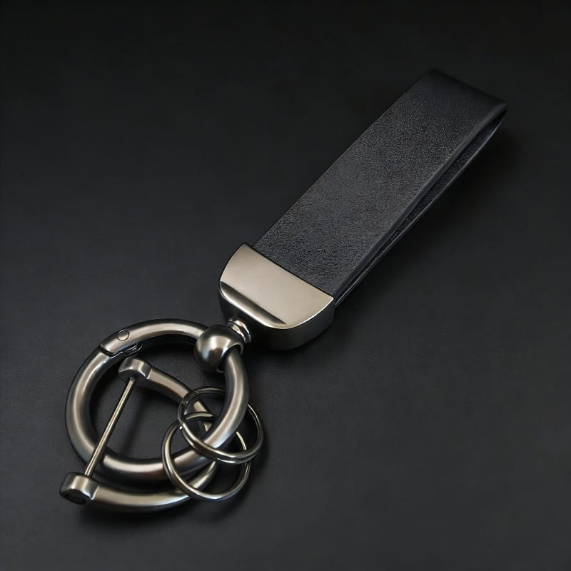 Black leather keychain with sleek metallic ring and carabiner attachment custom engraved for a personalized gift.