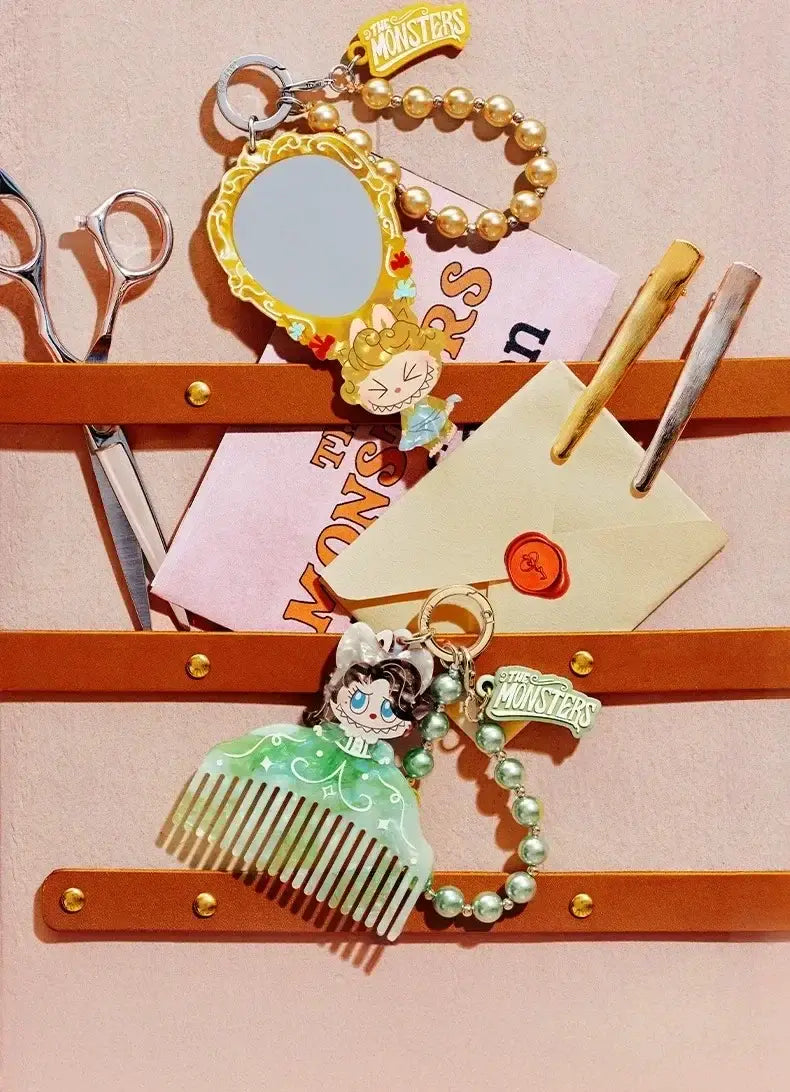 Ein mintgrüner, akrylähnlicher Kamm-förmiger Schlüsselanhänger mit einem Cartoon-Charakter mit langem dunklem Haar und einer Schleife, an einer Perlenkette von Pop Mart Labuub the Monsters Hair Salon Guess Bag.