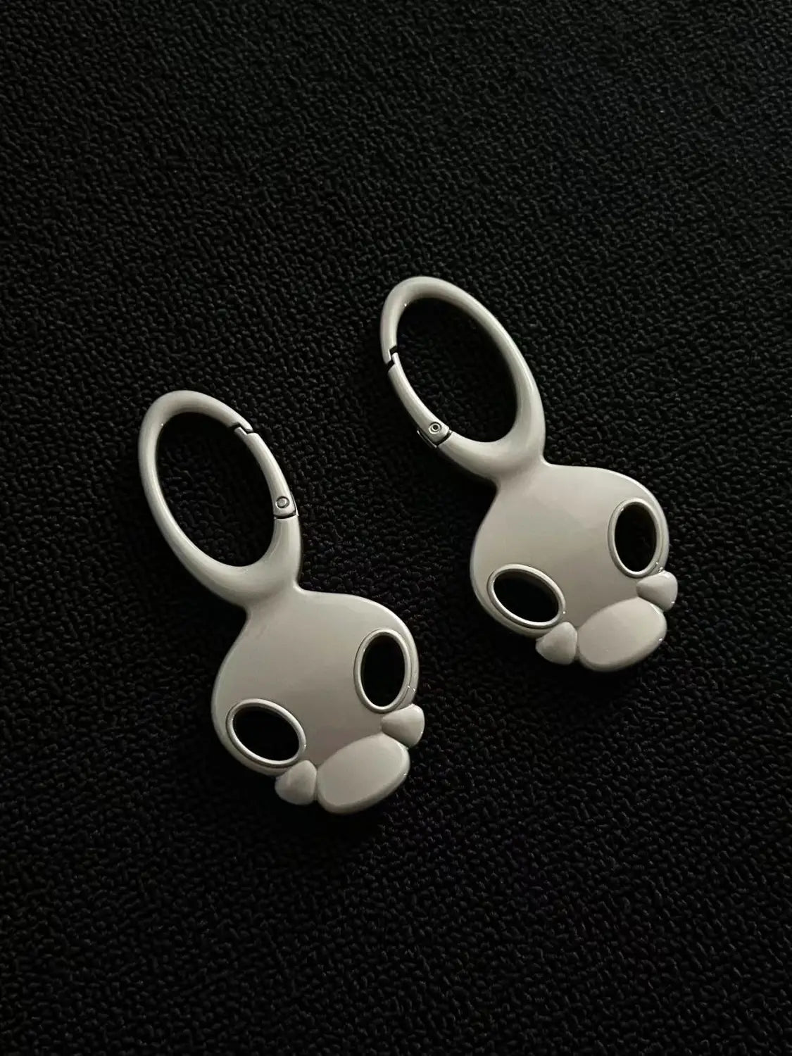 White ceramic bunny-shaped keychain with a smooth glossy finish and minimalist design used as a bag charm in the skull metal car keychain collection.