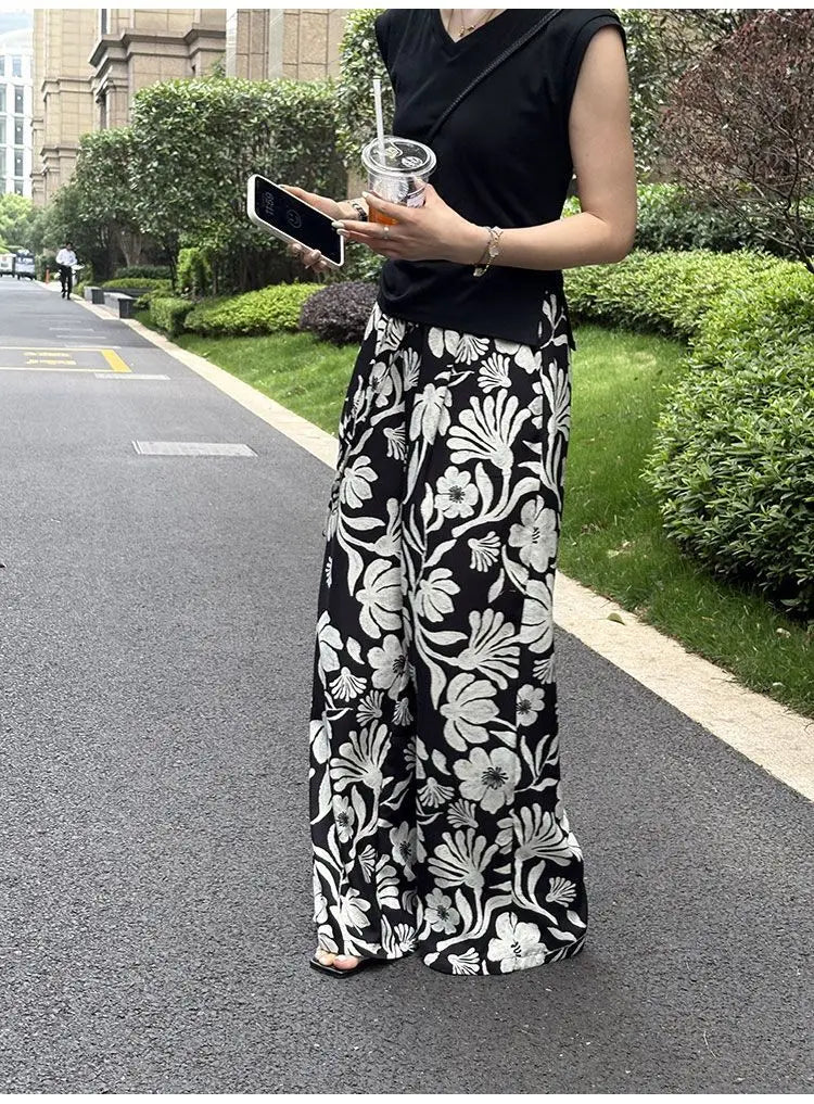 pantalons à jambes évasées et imprimé floral pour femmes, noir et blanc, avec un imprimé floral audacieux et un design confortable à jambes évasées.