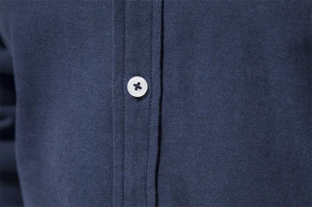white button with black cross design on textured navy blue fabric of dress shirts contrast collar long sleeve men suitable for fashion social shirts