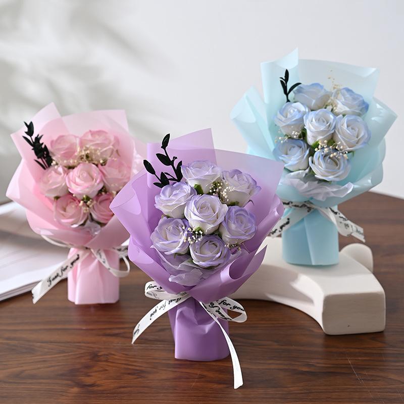 Artificial rose flower bouquet for gifts featuring three delicate pastel-colored bouquets wrapped in matching tissue paper and tied with ribbon.