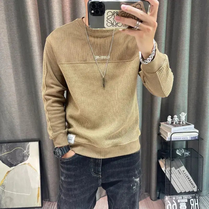 Pull-over en maille à empiècement contrastant pour homme, manches longues, en maille côtelée beige, avec un empiècement texturé contrastant sur la poitrine et une broderie blanche discrète au niveau de l’encolure.