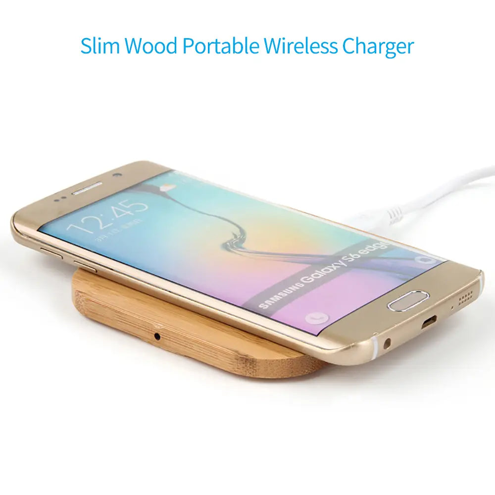 Teléfono inteligente Samsung Galaxy S6 Edge en color dorado apoyado sobre una alfombrilla de carga inalámbrica de madera delgada con funcionalidad de cargador rápido USB C