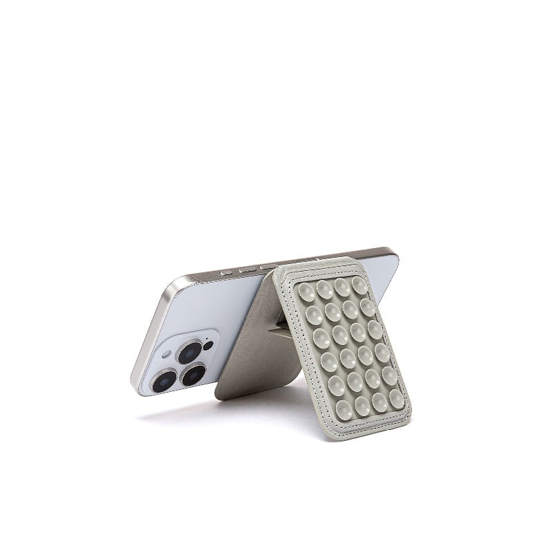 Gray leather foldable magnetic card holder phone stand with a grid of circular suction cups visible from the front.
