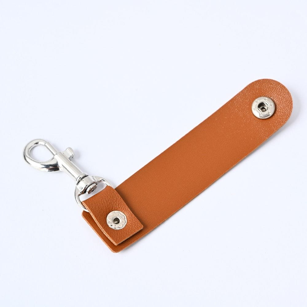 Hellbrauner Pu-Leder-Schlüsselanhänger mit silberfarbenem Metallverschluss und Druckknöpfen, ausgelegt als Anti-Verlust-Autoschlüsselriemen-Anhänger.