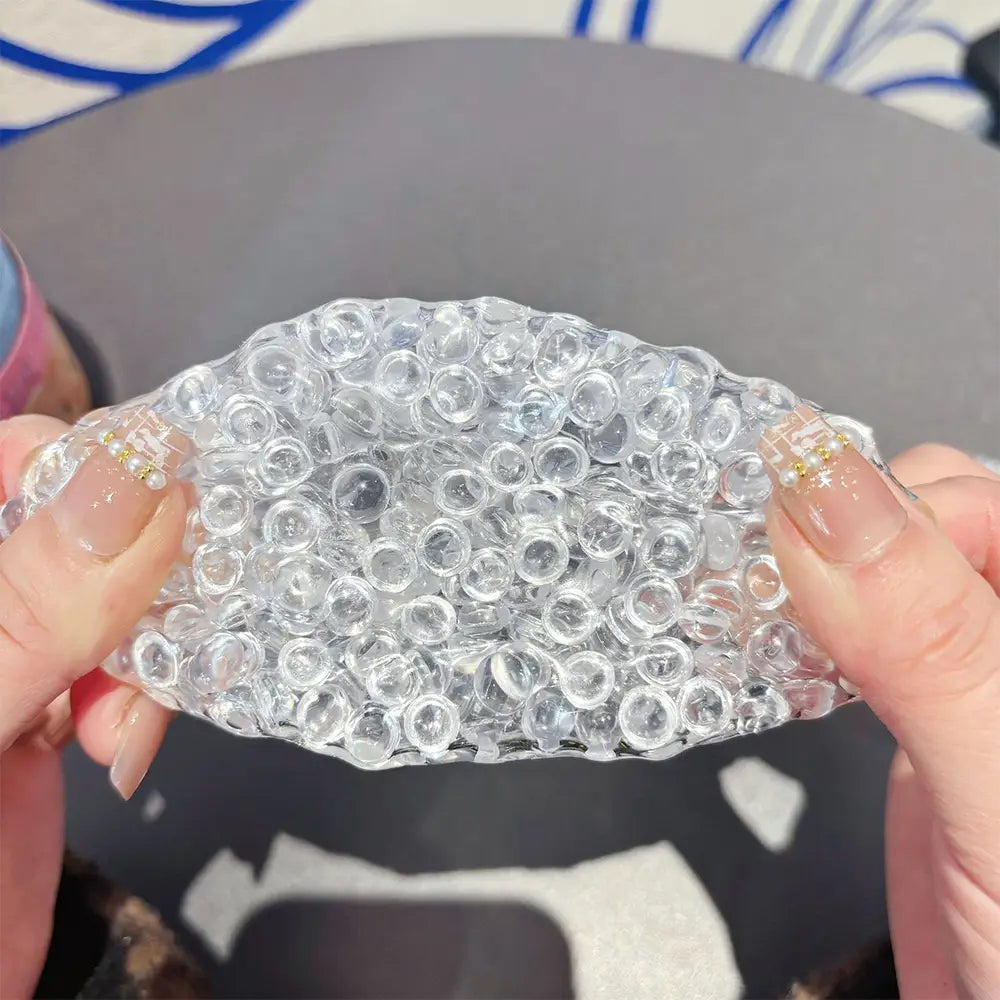 Jouet anti-stress à perles de glace en gel à presser présentant des perles de gel de type cristallin transparent, composées d’innombrables petites sphères translucides étroitement disposées.