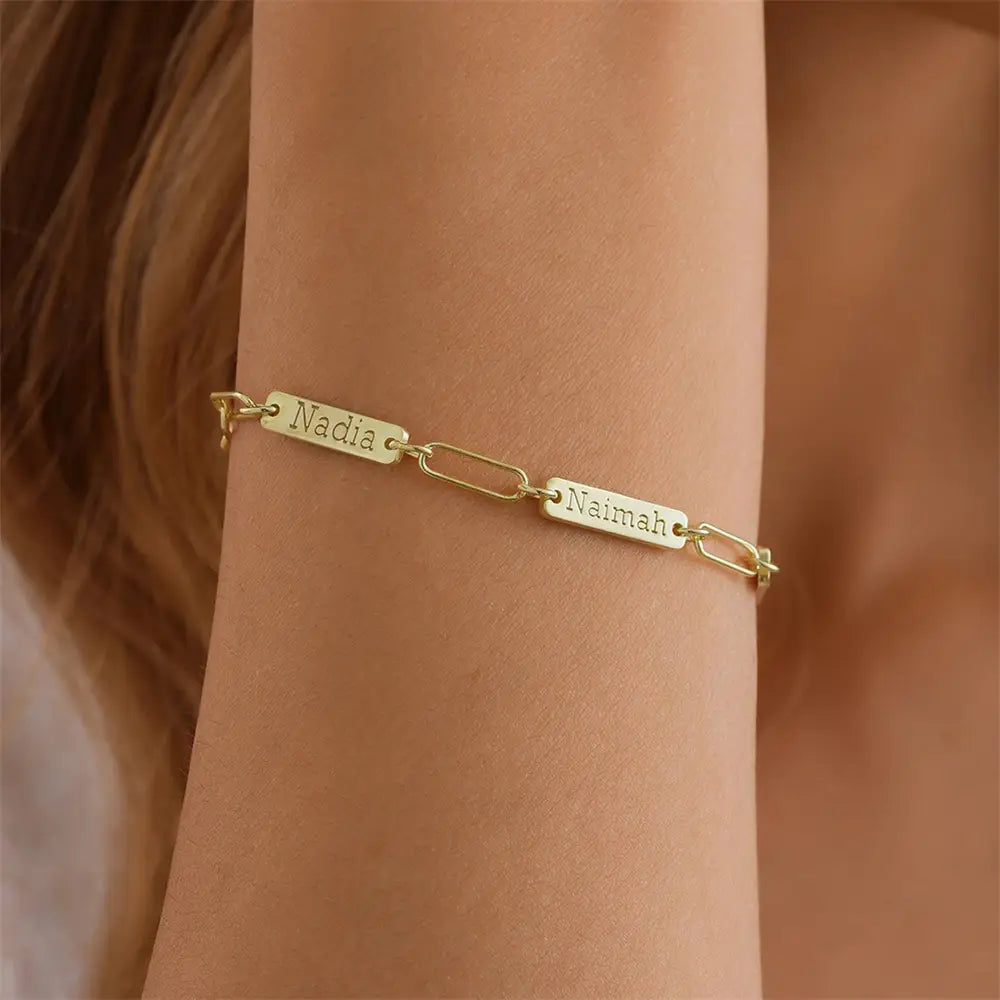 Armband mit goldfarbenem Kettenzubehör mit zwei rechteckigen Namensplaketten, graviert mit „nadia“ und „naimah“, individuell graviert für Herren.
