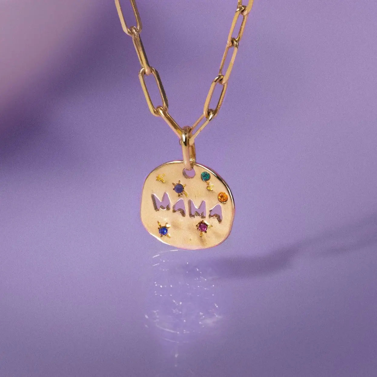 Collier en acier inoxydable doré avec pendentif en pierre précieuse « Mama », agrémenté d'accents de pierres précieuses colorées et d'une chaîne de style « paperclip ».