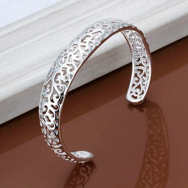 Sterling silver filigree cuff bracelet featuring intricate swirling patterns and a polished finish.