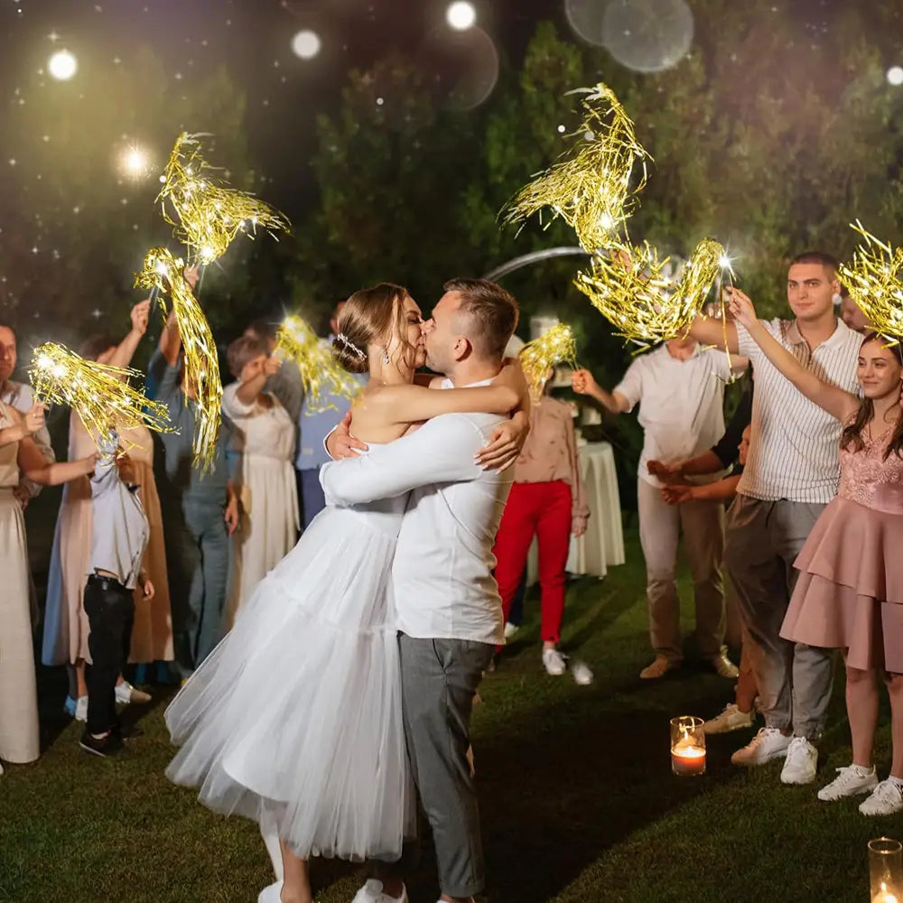 Robe de mariée en tulle blanc assortie à des bâtons lumineux de mariage à LED comprenant des rubans en tinsel doré, pour un accessoire de célébration festif.